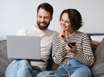 Happy young white couple sitting on a couch at home